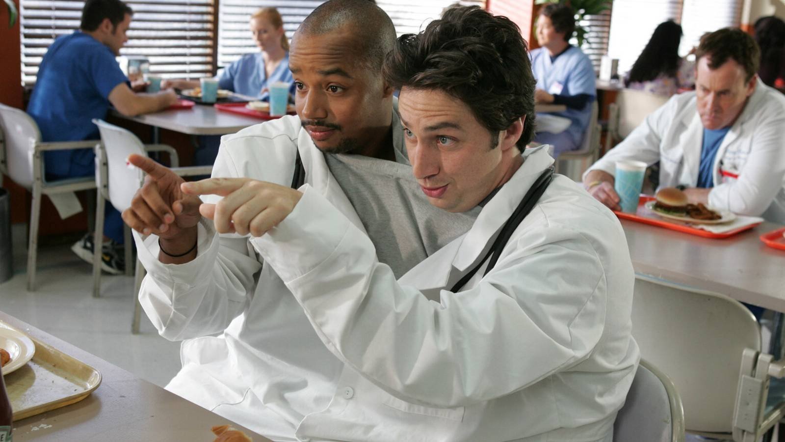 A scene from Scrubs of Donald Faison as Turk and Zach Braff as J.D. pointing at something