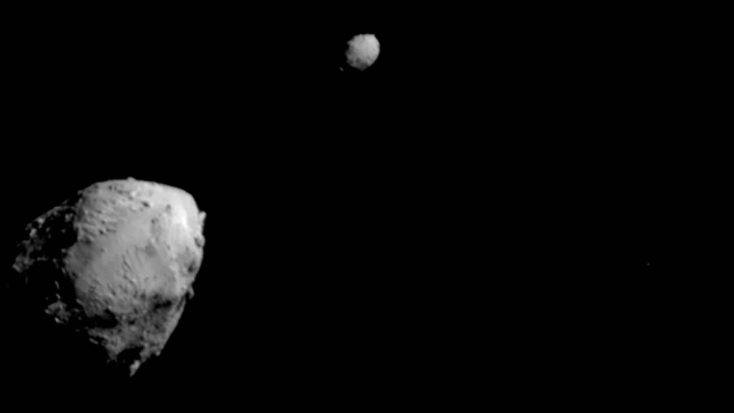 NASA’s DART spacecraft took this picture of asteroid Didymos (bottom left) and its smaller comp...