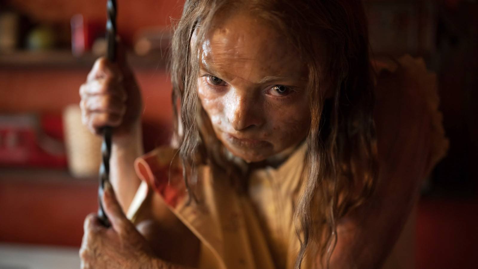 Katie bent over and holding a fireplace tool in Lee Cronin's The Mummy