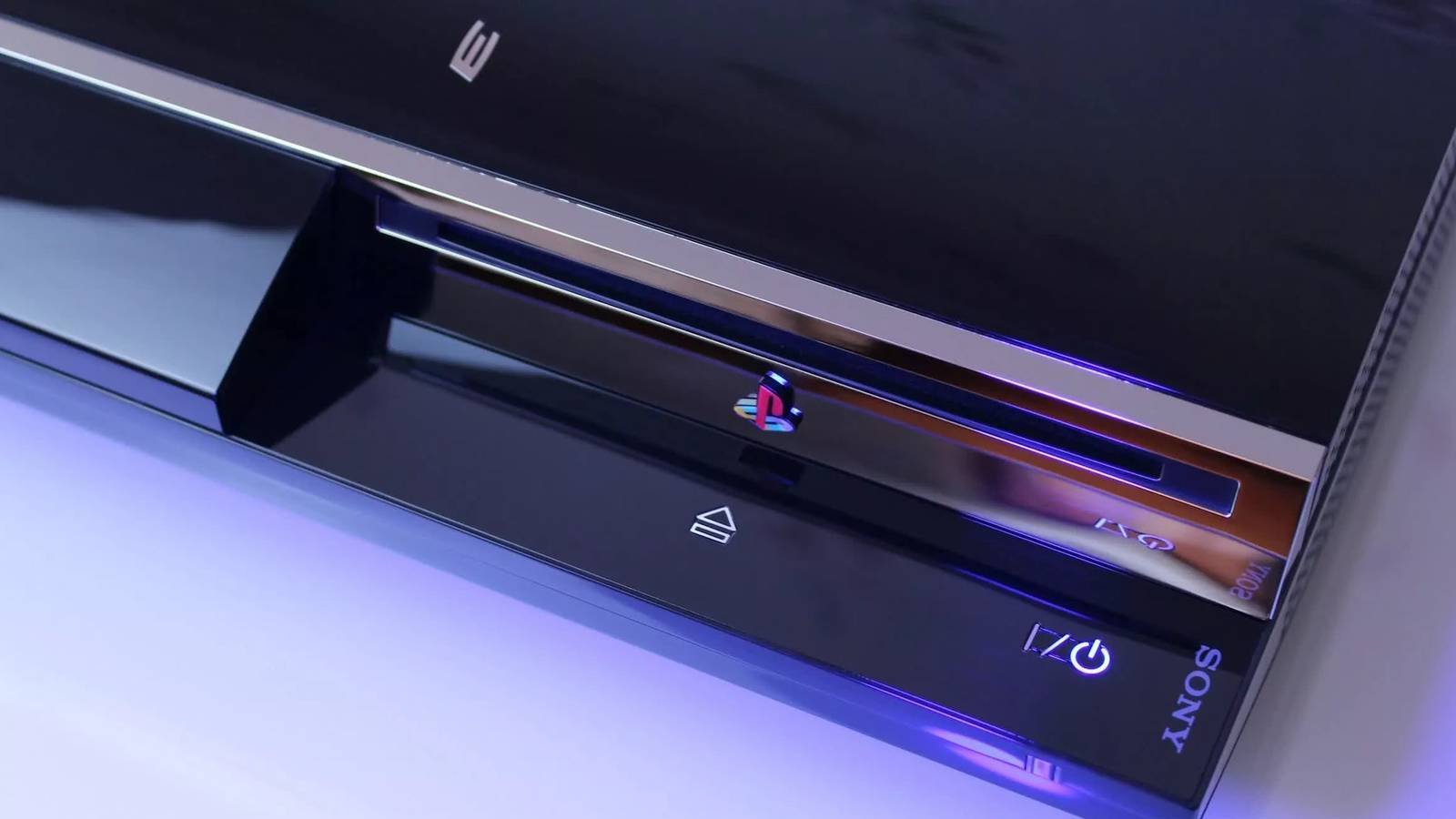 Close-up on a PlayStation 3 disc drive, showing the classic PlayStation logo.