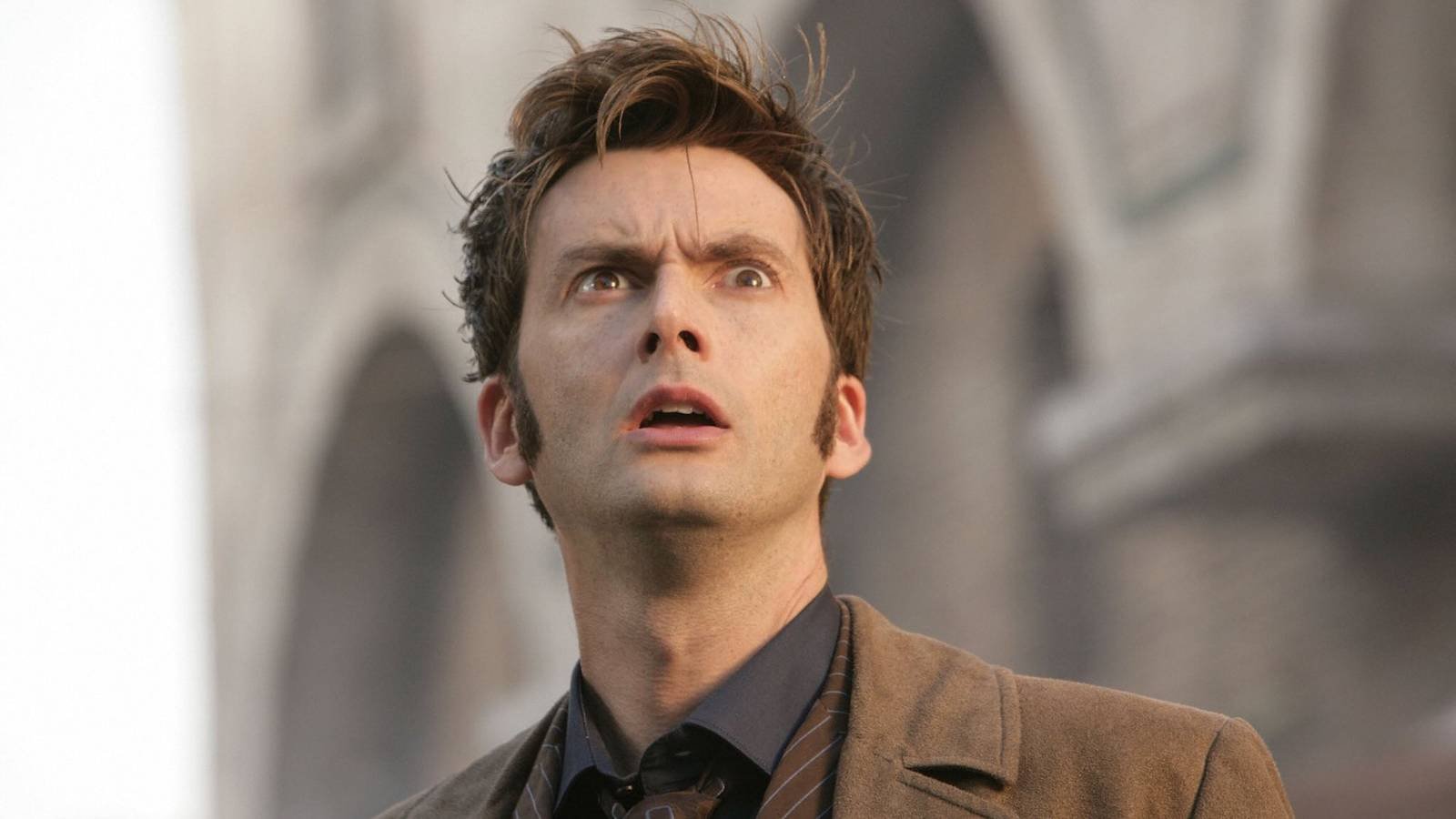 David Tennant's Tenth Doctor looking up at something with a surprised expression.