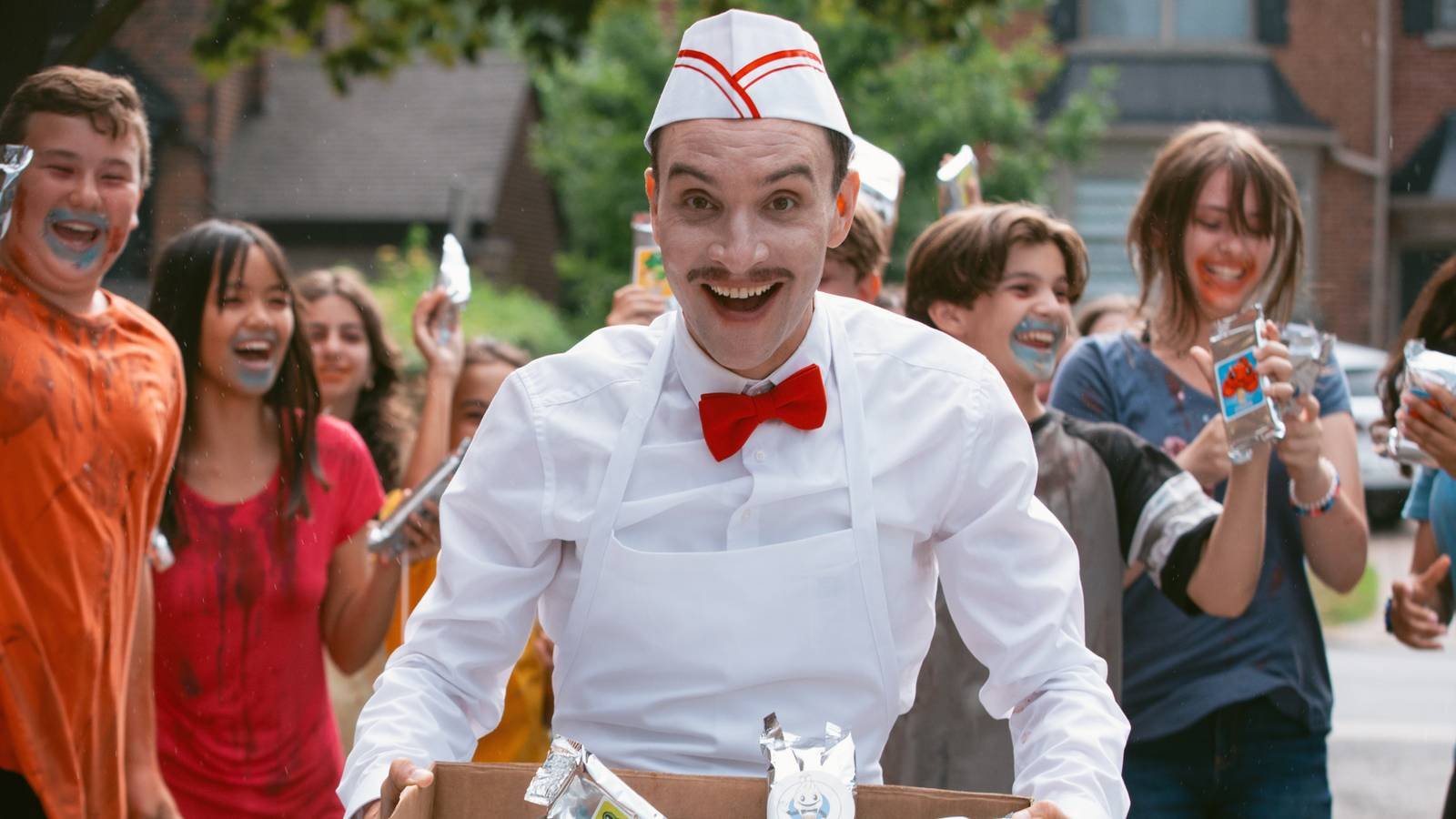 The Ice Cream Man smiling as kids celebrate behind him