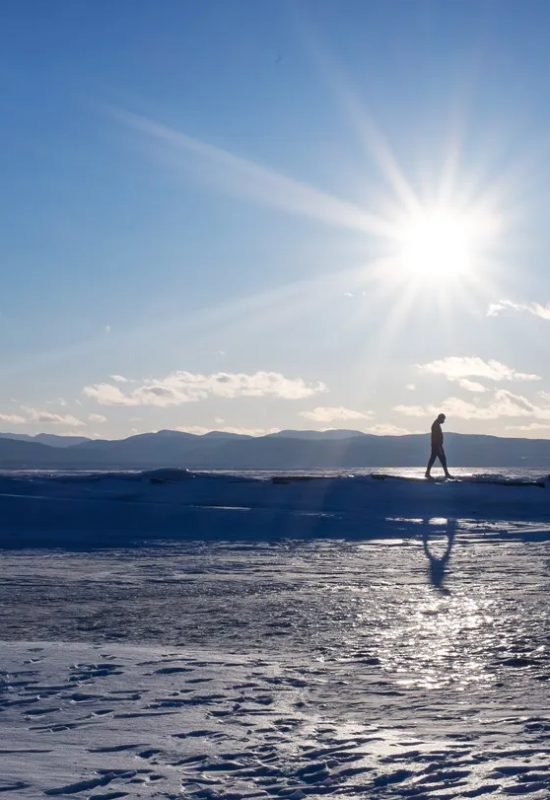 A man walks across frozen Lake Champlain in Burlington, Vt., in February. The lake, which used to...